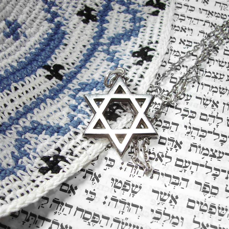 Star of David laying on paper with Jewish scripture.